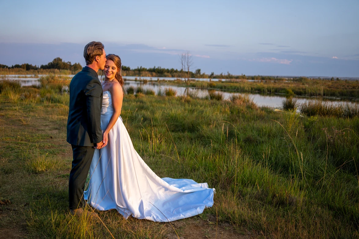 Bride and groom at sunset by the water
